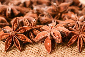 Star anise. Some star anise fruits with seeds 6. Macro close up on the jute burlap canvas.