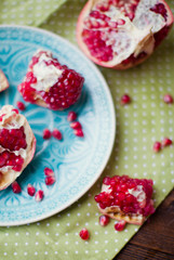 Ripe pomegranate fruit on blue plate