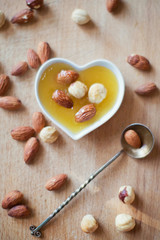 Fototapeta na wymiar almonds and hazelnuts with honey