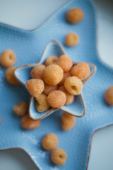 yellow raspberry in blue plate