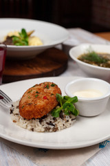 Close up of crunchy breaded cutlet with white steamed basmati rice and mayo as a part of restaurant set menu, served in a white plate
