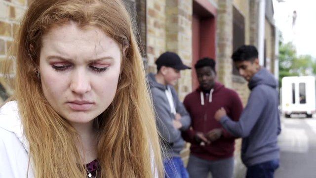 Unhappy Teenage Girl Being Gossiped About By Peers
