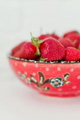 Fresh juicy strawberries in the red bowl