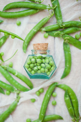 fresh green peas and small glass bottle