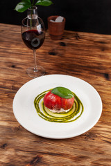 Top view of peeled tomato Bull's Heart, stuffed with tuna and flavoured with fresh pesto sauce