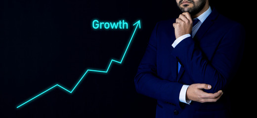 businessman on a black background with a growing arrow, growth chart, progress; business concept