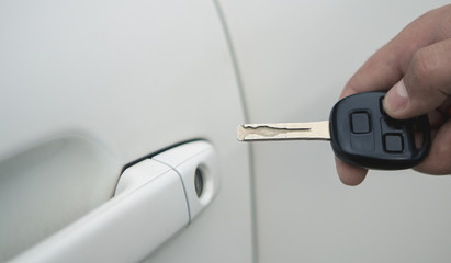 hand of a young man with a key opens the door of the car