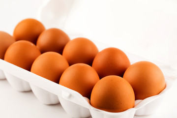 brown eggs in plastic package on white background.
