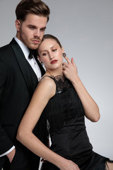 Handsome groom standing his girlfriend is leaning on him