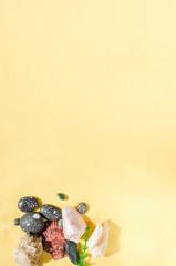 Flat lay of seashells, pebbles and seaweed on yellow background. Trip and travel planning concept. Summer background