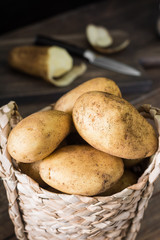 Raw potatoes in the basket. Rustic style