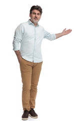 Casual man presenting and holding his hand in his pocket