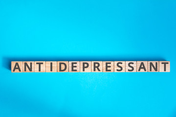 antidepressant inscription wooden cubes with letters on a blue background