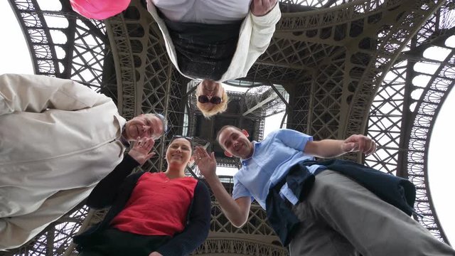 Happy family having fun and sending greetings under the Eiffel Tower in Paris in 4k slow motion 60fps