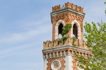Tower at the entrance of the Arsenale in Vencie Italy, ovegrwon with climbers