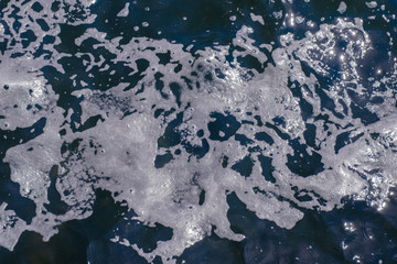 Sea water and sea foam at the shore. Creative vintage background.