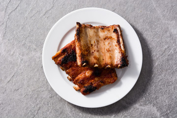 Grilled barbecue ribs on gray stone background