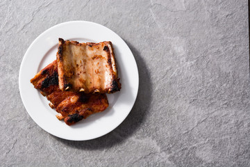 Grilled barbecue ribs on gray stone background
