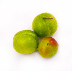 Three green tomatoes next to each other. Along with raindrops.