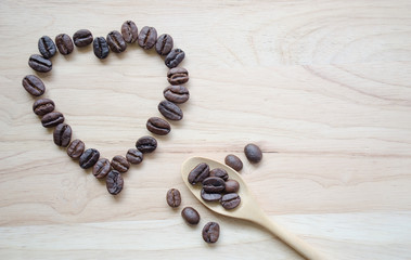 .Coffee beans with a wooden spoon, scoop, coffee beans and red hearts on a wooden background For...