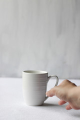 Coffee addiction, white coffee mug and hand