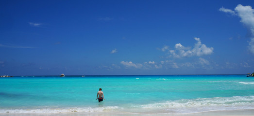 Fototapeta na wymiar Man swimming in Caribbean sea, Cancun beach, Mexico.