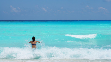 Woman swimming in Caribbean sea with a beautiful turquoise color. Vacation in Cancun, Mexico.