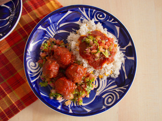 Italian Meatballs with a Local Twist Recipe that includes White Rice Spicy Tomato Sauce and Sliced Tomato Onions and Parsley 