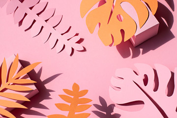 Paper tropical plants leaves on the pink background. Summer concept Top view