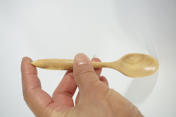 hand holding spoon wood