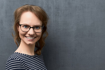 Portrait of happy young woman with glasses smiling broadly