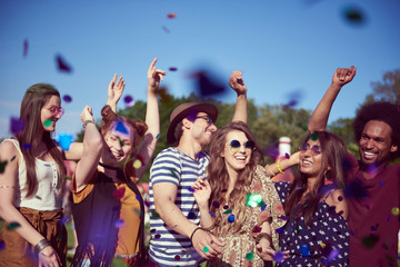 Group of friends dancing in confetti