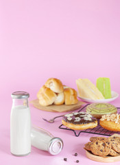 bottle of milk and various bakeries on a pink background