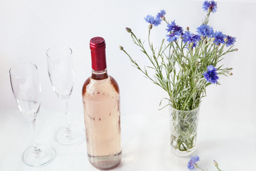 bottle of rose wine on a white background with glasses and strawberries