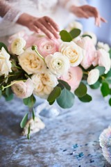 Very nice young woman holding big and beautiful colorful flower wedding bouquet. Blush Italian Cloony Ranunculus.