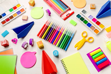 Plakat School supplies lay out with colorful stationery. Markers, color pencils, notebooks on wooden desk, top view