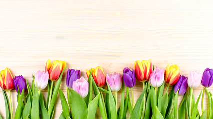 Pink, purple, yellow tulips on wooden background, flowers arrangement. Greeting card with flowers, copyspace © Maria Shchipakina