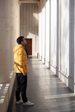 Man looking at fallen soldier names on Menin gate memorial wall