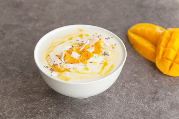 Mango smoothies bowl with coconut and Chia seeds. Vegan diet food concept. Healthy breakfast. 