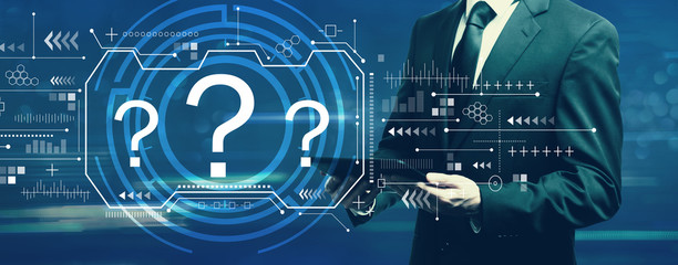 Question marks with businessman holding a tablet computer