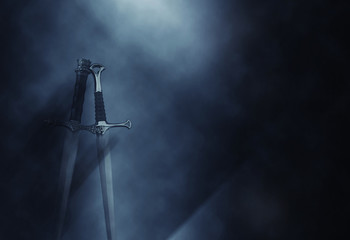 mysterious and magical photo of silver sword over gothic black background with smoke. Medieval period concept
