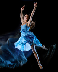 one caucasian young woman ballet dancer dancing isolated on black background with  light painting motion blur speed effect