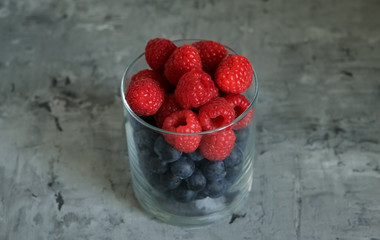 Fresh blueberries and raspberries in a glass. Raw
