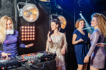 Dj woman having fun playing music on deck at club nightlife lifestyle. Female dj mixing music on...