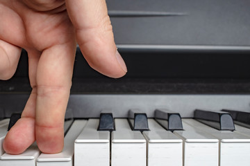 Fototapeta na wymiar Fingers click on the piano keys as if the legs.
