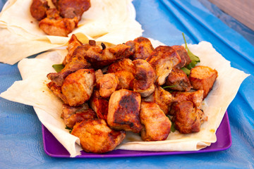 Chopped  bbq pieces of  mutton, beef or chicken meat on the plate with greenery outdoor