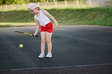 happy girl plays tennis on court outdoors