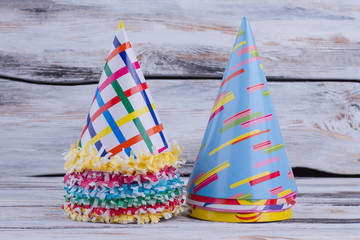 Birthday party hats on gray wooden background. Funny festive decoration.