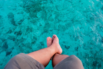 legs on the beautifully clear sea in the Maldives