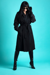Femme trench et solaire en studio 